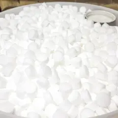 Un grand seau rempli de pastilles blanches de sel régénérant, prêtes à purifier l'eau.