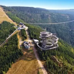 Widok na Sky Walk i najdłuższy most wiszący na świecie, otoczone gęstym lasem i górskimi zboczami.