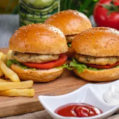 Pyszne burgery z piekarnika z chrupiącymi frytkami, pomidorami i sałatą. Idealne na szybki obiad.