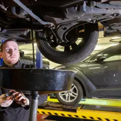 Mechanik wymienia olej w samochodzie. Zastanawiasz się, ile kosztuje zmiana oleju? W warsztacie samochodowym to standardowa usługa.
