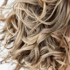 Cabello rubio ondulado y sedoso, libre de sulfatos y parabenos, con reflejos dorados.
