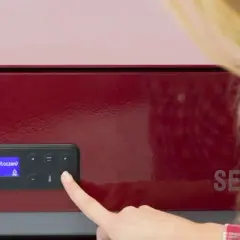 Kobieta sprawdza na wyświetlaczu pieca pellet temperaturę spalin.
