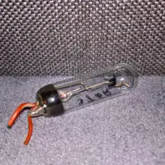 Szklana bańka z elementami elektronicznymi i czerwonymi przewodami. Tak wygląda prostownik, który kiedyś zasilał urządzenia.