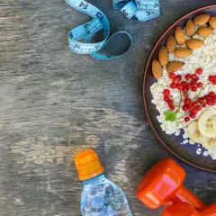 Zdrowa owsianka z owocami, migdałami, wodą i hantlami. Czy białko pomaga schudnąć? To śniadanie to dobry początek!