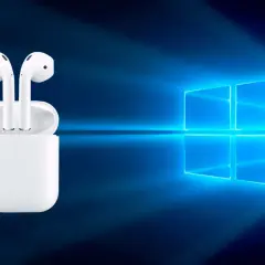AirPods w etui na tle logo Windows. Czy da się podłączyć AirPods do laptopa? Tak, to możliwe!