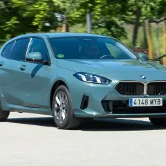 Un BMW Serie 1 gris circula por una carretera. El motor BMW 1.5 3 cilindros es eficiente, pero algunos usuarios reportan problemas.