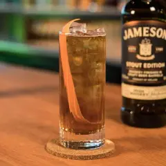 Orzeźwiający drink z whisky Jameson Stout Edition, lodem i skórką pomarańczy. Idealny na wieczór.