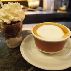 Deser z bitą śmietaną i kawa latte, jakby zrobione z tazza d'oro.