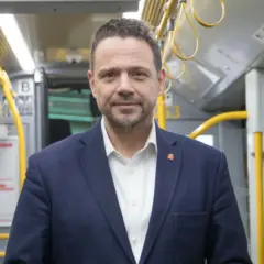 Rafał Trzaskowski, prezydent Warszawy, w środkach komunikacji miejskiej. Jego życiorys to historia zaangażowania w rozwój stolicy.