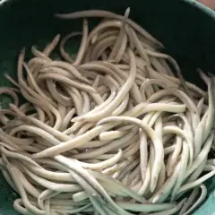 Un cuenco verde lleno de angulas congeladas, listas para ser cocinadas.