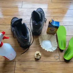 Gather supplies to learn how to clean hiking boots: boots, spray bottle, baking soda, coffee filter, and insoles.