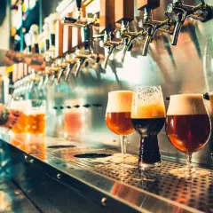 Barman sert des bières artisanales. Est-ce que la bière hydrate ? La réponse est complexe, mais ces verres invitent à la dégustation.