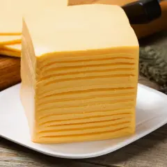 Una pila di sottilette su un piatto bianco, perfette per uno spuntino in gravidanza.