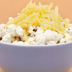 Miseczka popcornu z tartym serem. Pyszna przekąska, ale warto pamiętać o jej popcorn kcal.