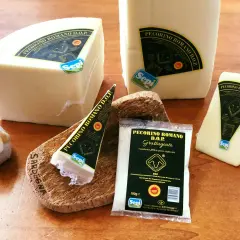 Ser pecorino romano DOP w kawałkach i starty, obok owieczki. Idealny do makaronu.