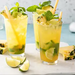 Orzeźwiające augustowskie mojito z ananasem, miętą i limonką, podane z kostkami lodu i słomkami.