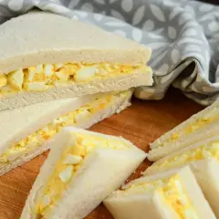 Délicieux tamago sando, des sandwichs au pain de mie blanc et à la garniture crémeuse aux œufs, coupés en triangles.
