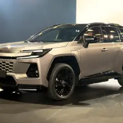 Nowy Toyota RAV4 2026 w kolorze szampańskim, z czarnymi felgami i przyciemnianymi szybami, prezentowany na scenie.
