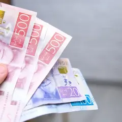 Dłoń trzyma banknoty 500 koron szwedzkich. To pokazuje, jaka jest waluta w Szwecji.