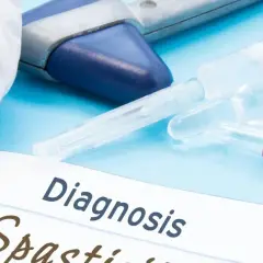 Medyczne narzędzia i ampułki na niebieskim tle. Na papierze widnieje napis "Diagnosis Spastyczność mięśni".