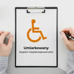 Na tablicy widnieje symbol osoby na wózku inwalidzkim i napis "Umiarkowany stopień niepełnosprawności".