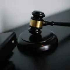 Młotek sędziowski i akta sądowe. Dowiedz się, jak uzyskać protokół z rozprawy sądowej.