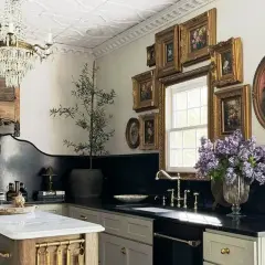 A luxurious kitchen with a crystal chandelier, ornate wood paneling, and a collection of framed floral paintings, evoking the grandeur of Victorian houses.