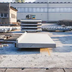Gotowe do montażu elementy, w tym betonowy balkon prefabrykowany, czekają na placu budowy.