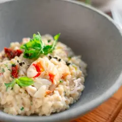 Un crémeux risotto aux fruits de mer, garni de basilic frais et de tomates séchées. Une recette de pâtes qui invite au voyage.