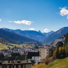 Widok na miasteczko w dolinie otoczonej górami. W oddali widać kościół z wieżą. Tak właśnie wygląda Davos.
