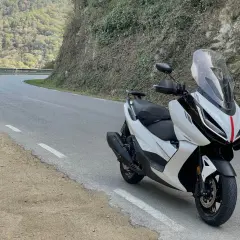 Scooter Zontes blanca en carretera sinuosa. Opiniones sobre motos Zontes: diseño moderno y ágil para rutas de montaña.