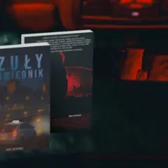 Okładki książek "Czuly Spowiednik" i innej powieści Pawła Rutkowskiego. W lusterku wstecznym odbija się twarz kierowcy.
