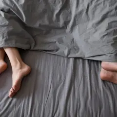 Stopy pod kołdrą. Kobieta z PCOS może doświadczać zmian w libido, co wpływa na intymność.