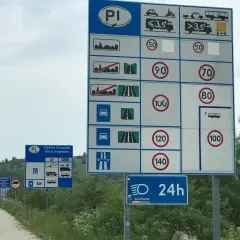 Znaki drogowe informują, ile można jechać z przyczepką na autostradzie. Maksymalna prędkość dla pojazdów z przyczepą to 100 km/h.