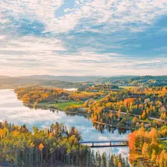Herbstliche Landschaft in Schweden mit einem See, bunten Wäldern und einer Brücke. Ein Ort, den man gesehen haben muss!