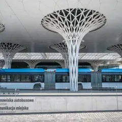 Nowoczesny dworzec autobusowy w Lublinie z niebieskim autobusem. Architektura przypomina drzewa, jakby podróż z Torunia do Lublina była podróżą przez futurystyczny las.