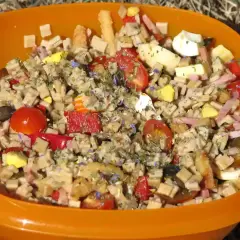 Salade de crozets au thon, garnie de tomates cerises, œufs durs, jambon et herbes. Un plat coloré et savoureux.