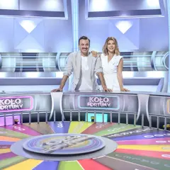 Prowadzący program "Koło Fortuny" stoją przy kole, gotowi do gry.