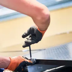 Pracownicy montują panele słoneczne. Sprawdź, jaka jest demontaż paneli podłogowych cena, gdy potrzebujesz zmian.