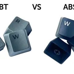 PBT vs ABS Tastenkappen: Graue PBT-Tasten (R, W) und schwarze ABS-Tasten (W, S) mit ihren jeweiligen Unterseiten.