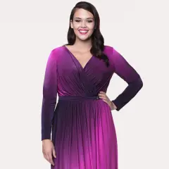 Uśmiechnięta modelka w butik na plus sukienki. Długa, fioletowo-różowa sukienka z dekoltem kopertowym i długimi rękawami.