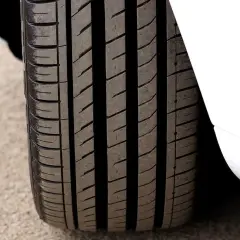 Gros plan sur un pneu 4 saisons, prêt pour le test. Sa bande de roulement profonde promet une bonne adhérence sur toutes les surfaces.