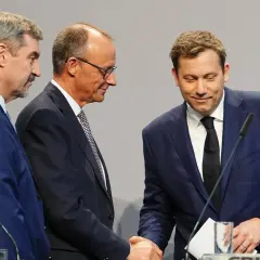 Drei Männer in Anzügen schütteln Hände. Sie repräsentieren Parteien, die überlegen, welche Partei Deutschland regiert.