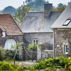 Kamienne domy z dachami z dachówki i łupka, z kominem i wyczystką do kominka.