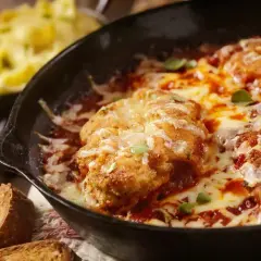 Zapiekanka z kurczakiem w sosie pomidorowym, roztopionym serem i pieczywem.