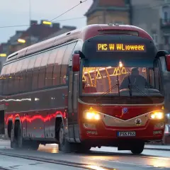 Czerwony autobus PKS jedzie ulicą. Zastanawiasz się, jaka jest pks bilet miesięczny cena?