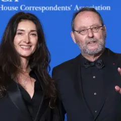 Jean Reno z żoną, Zofią, na tle niebieskiego banera White House Correspondents' Association.