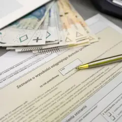 Złożenie PIT-37 z pieniędzmi i długopisem. Zeznanie o wysokości osiągniętego dochodu, pierwszy próg podatkowy.
