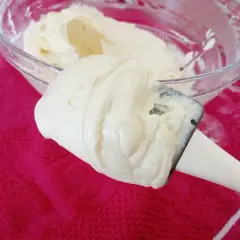 Crème onctueuse de mascarpone sur une spatule, prête pour une délicieuse recette.
