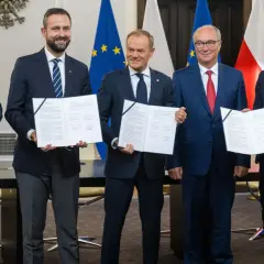 Pięciu polityków prezentuje dokumenty. Ich uśmiechy sugerują sukces, być może związany z tym, ile posłów ma koalicja rządząca.